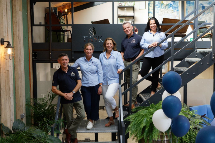 A group of people (5) posing and standing on metallic stairs with blue and white balloons